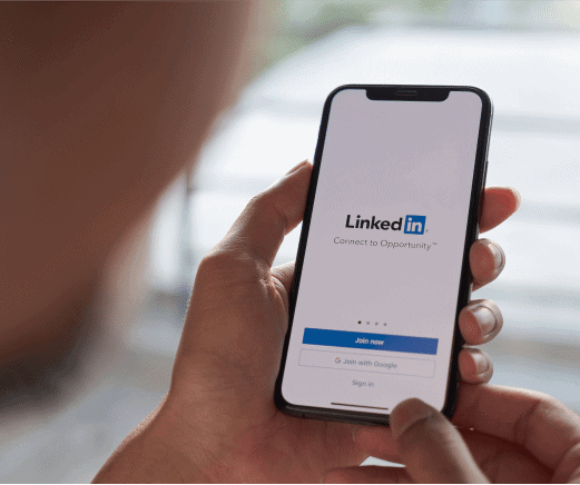 Person holding a smartphone with the LinkedIn app login screen open
